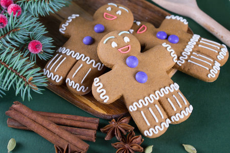 Christmas and holiday baking . Ginger men cookies with dÃ©cor on  green  background.