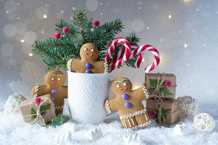 Christmas or new year card . Cup with fir trees, candy canes and ginger cookies. On snow bright background.の写真素材