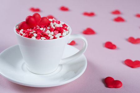 Valentine's Day background . Many little colorful sprinkles hearts in a cup. Creative concept.の写真素材