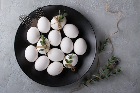 White chicken raw  eggs on a black plate. Top view and copy space. Easter  photo concept.の写真素材