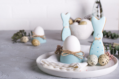 Homemade easter cookies in the shape of  a  funny  bunny, quail eggs  and chicken egg. Easter  celebration table setting. Holiday decorations.の写真素材