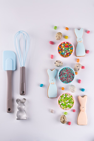 Preparation of gingerbread easter cookies. Cookie cutters, cookies in the shape of funny  bunny and kitchen tools の写真素材