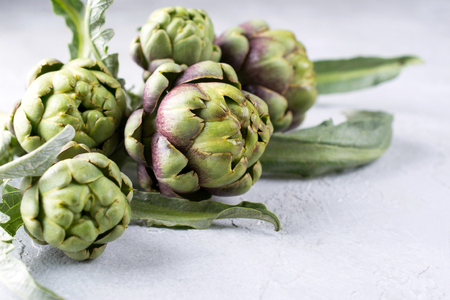 Fresh  raw artichokes on grey background. Ripe organic artichoke flower with copy spaceの写真素材