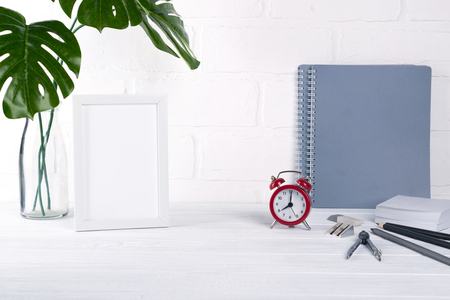 Back to school, business office education concept. Assortment of supplies, crayons, pens, notebook, alarm clock on a table. With copy spaceの写真素材
