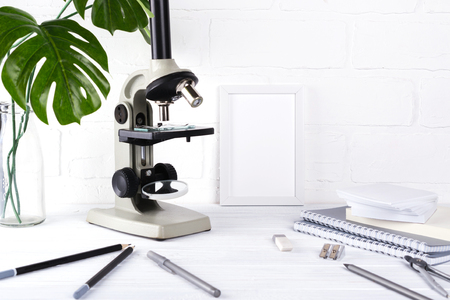 Biology education concept - Assortment of supplies,  microscope on white background Minimalistic school or office workspaceの写真素材