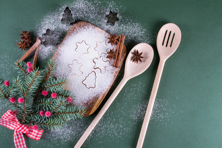 Christmas and holiday baking background. Fir trees with decoration, flour, spices and cookies molds on a cutting board.の写真素材