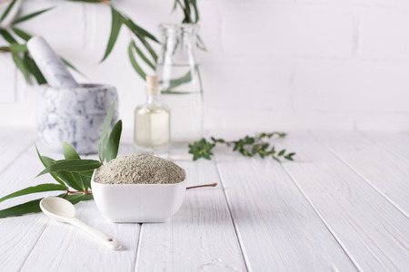 Dry facial clay powder in bowl. Natural cosmetics for home or salon spa treatment on white backgroundの写真素材