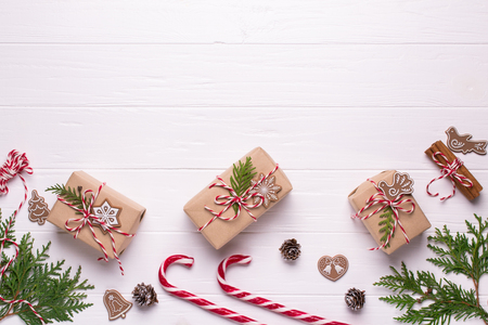 Frame with christmas gifts and candy cane, decorations , pine cones, fir branches top viewの写真素材