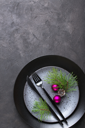 Christmas menu concept . Flat lay with Xmas decorations, dark plates, fork and knife set with napkin. Copy spaceの写真素材