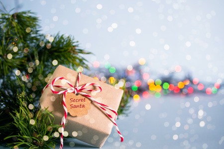 Gift exchange. Boxe with note Secret Santa fir branch and christmas toys on blue pastel backgroundの写真素材