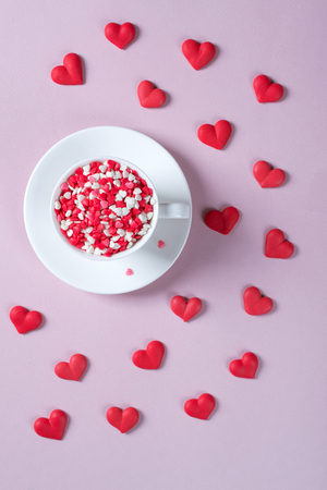 Coffee cup with colorful sprinkles hearts. Love and Valentine's day concept. Festive background. Flat lay.の写真素材