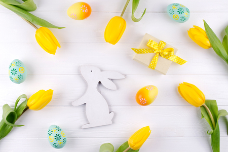 Happy Easter card. Frame with yellow tulips and easter eggs and bunny with copy space for text on white background. Top viewの写真素材