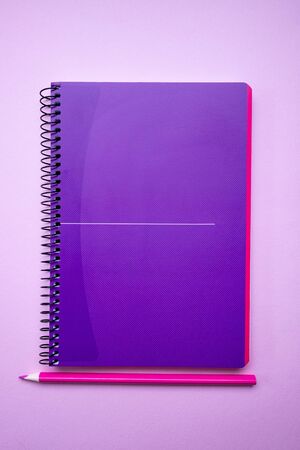 Purple notebook and pencil on paper background. Minimal back to school concept. Top viewの写真素材