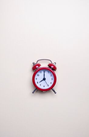 Red alarm clock on light pastel background. Blank note for text. Reminder. Space for copy. Minimal concept.の写真素材