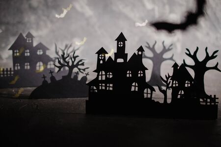 Halloween night background. Paper art. Abandoned village in a dark misty forestの写真素材
