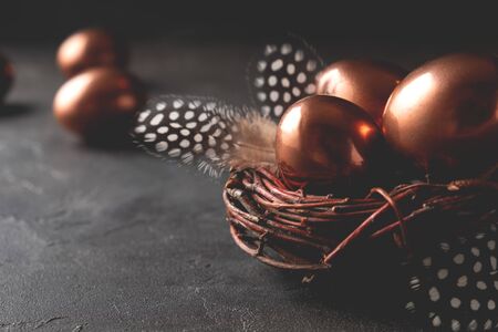 Easter composition with eggs in a nest  and feather on dark background. Easter greeting cardの写真素材