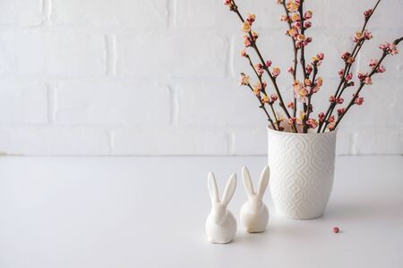 Easter composition with flowering pink cherry branch in vase on whiteの写真素材