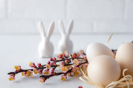 Easter spring decorative composition  with easter eggs pink cherry branch and ceramic bunny.