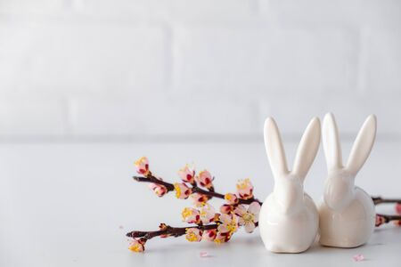 Easter spring decorative composition  with white easter ceramic bunny,  pink cherry branch.の写真素材