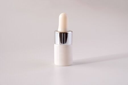 White cosmetic skincare dropper bottle packaging on white backgroundの写真素材