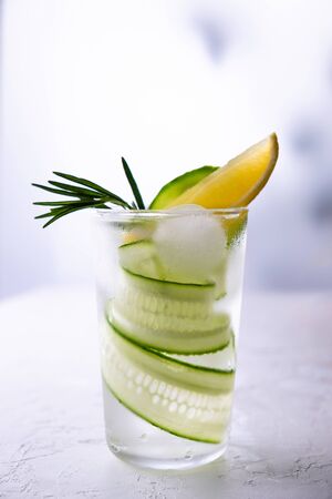 Fresh drink, gin tonic cocktail with cucumber, lemon and ice on white background. On white backgroundの写真素材