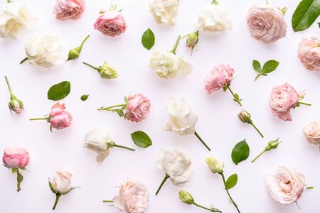 Floral composition , pattern made of pink and beige roses, green leaves, on white background. Flat lay, top view. Flowers pattern textureの写真素材