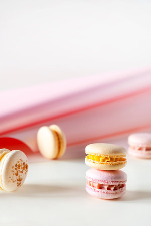 Colorful pastel french macaroons or macarons on white and pink backgroundの写真素材