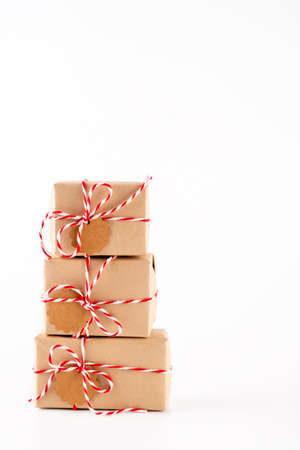 Gift boxes in craft paper, creative and zero waste gift wrapping, sustainable christmas. Stack of boxes like a Christmas tree on white backgroundの写真素材