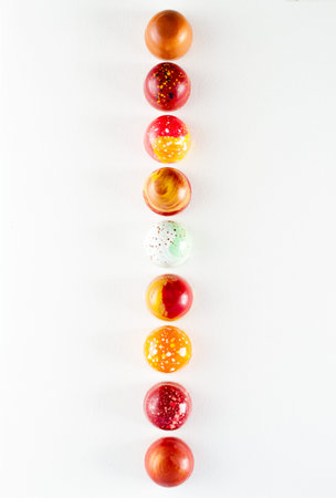 Modern hand painted with different colors chocolate candy placed in a row. product advertising...