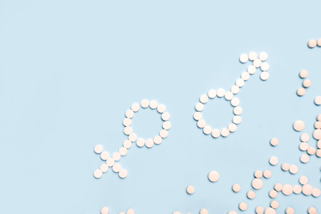 Medical pills in female and male symbol shape on a light blue background. Concept female and male health, contraception, pregnancy, fertilityの写真素材