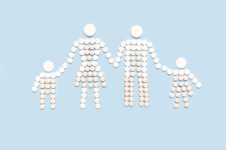 Family made of pills holding hands on blue background. Family and kids healthcare.の写真素材