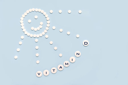 Pills in the form of the sun with rays and the word vitamin D on a blue background. VITAMIN D word for healthy and medical concept.の写真素材