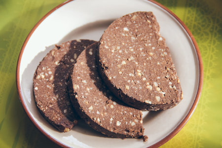 Sweet delicious chocolate dessert cut into pieces and sprinkled with cocoa on a plate