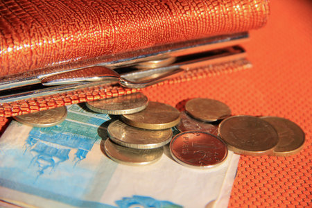 Wallet with money on orange background. Paper bills and change in an open purse. Russian money
