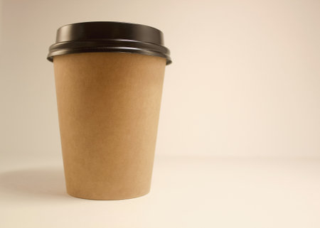 Rough paper Cup with coffee on a white background, copy space. Black plastic coverの写真素材