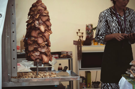 Uzbek girl in national dress and meat for shawarma in a street cafeの写真素材