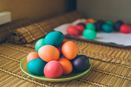 Bright multicolored painted Easter eggs on a green ceramic plate for the holidayの写真素材