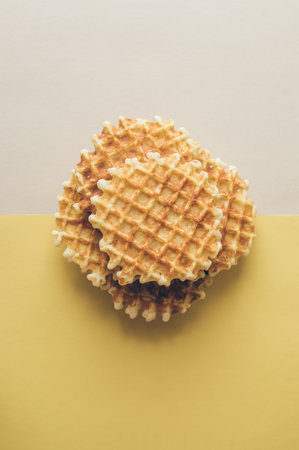 Delicious sweet homemade cookies on two-tone pale white and yellow background, concept of tea party.の写真素材