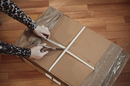 Unpacking furniture. Cutting the package with scissorsの写真素材