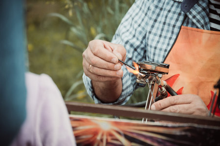 Glassblower blows handmade glass toys at a craft festival, close-upの写真素材