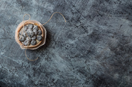Blueberry cakes with blue berries and a bow made of twine on a dark vintage background, copy spaceの写真素材