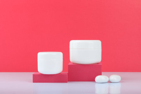 White cream jars on podiums against pink background with space for text. Concept of beautyの写真素材