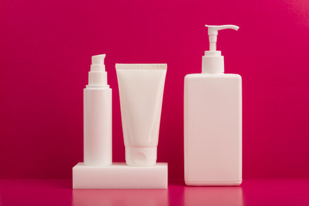 Set of creams or lotions on white podium against pink background on pink table. Concept of beauty treatmentの写真素材