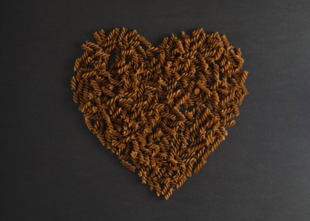 Top view of heart made of buckwheat pasta fusilli on dark background. Healthy lifestyle conceptの写真素材