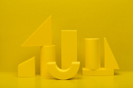 Abstract monochromatic composition with yellow geometric figures against yellow backgroundの写真素材
