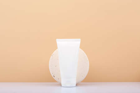 White cream tube with cream, lotion or gel against beige background with copy space.の写真素材