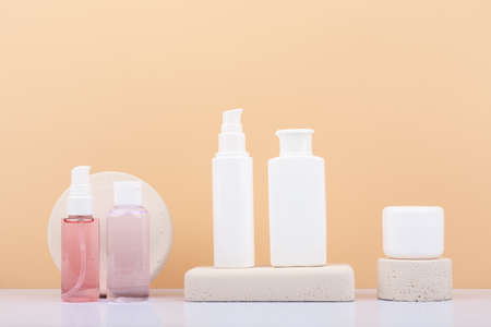 Set of skin care products on neutral stone podiums against beige background. Concept of skin care and beautyの写真素材