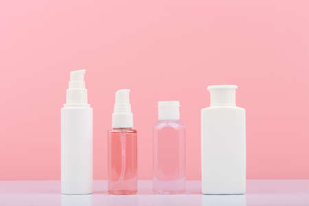 Set of cosmetic products for skin cleaning, exfoliating and moisturizing. Cosmetic bottles against pink backgroundの写真素材