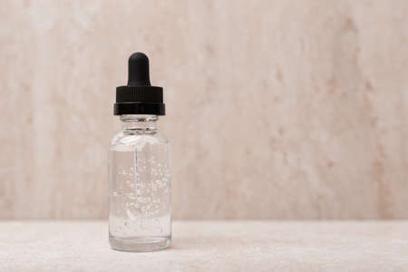 Selective focus, skin serum in transparent bottle in bathroom against blurred light marble background with copy spaceの写真素材