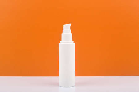 Face, neck or hands cream against orange background with copy spaceの写真素材